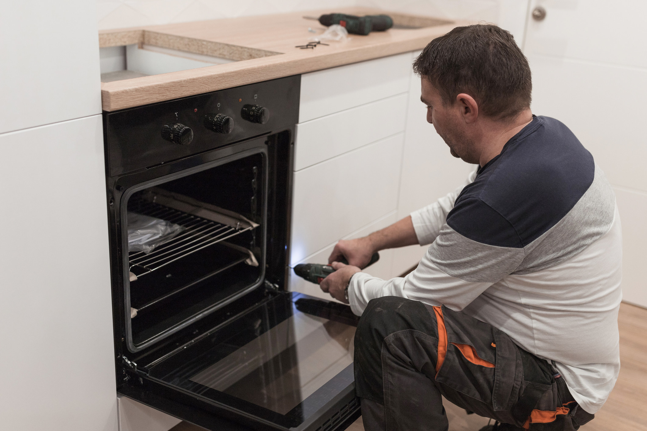 A handyman looking inside an oven