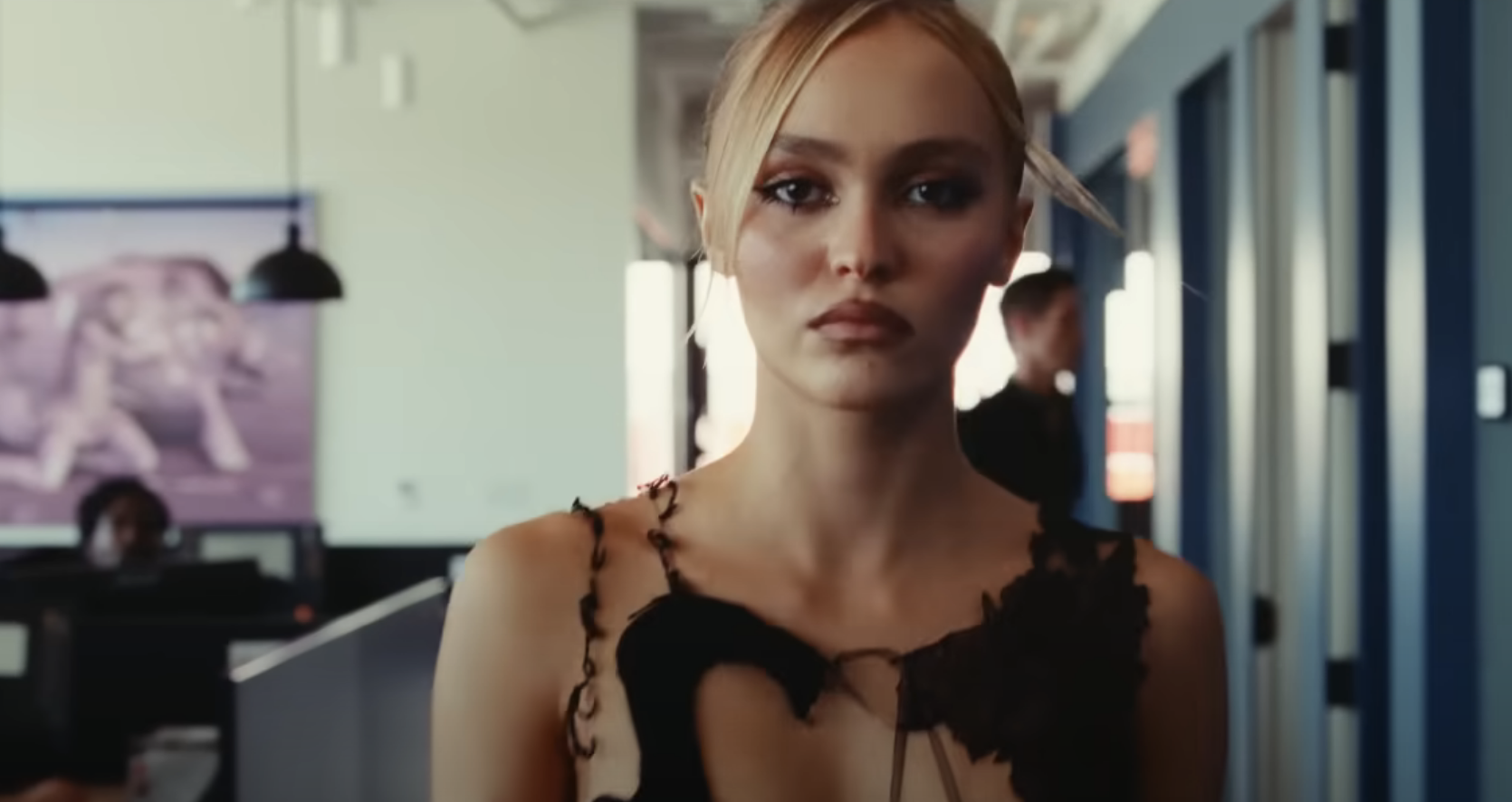 A closeup of Lily-Rose Depp walking down a hallway