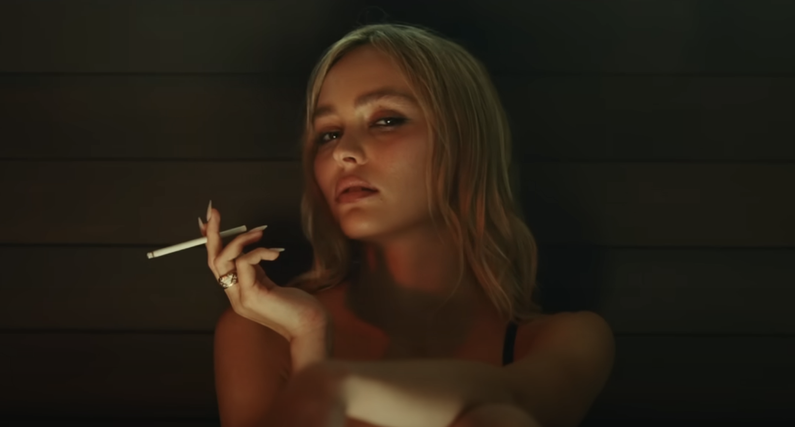 A close-up of Lily-Rose Depp smoking a cigarette