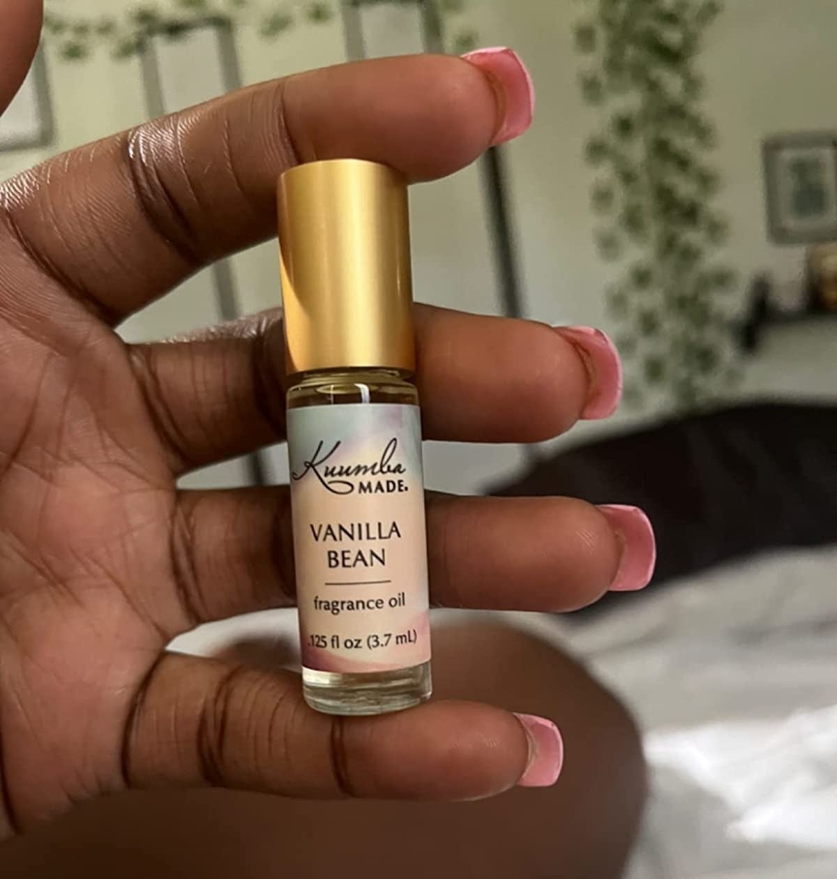 Reviewer holding a small bottle of vanilla oil