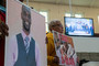 Activists hold signs showing Tyre Nichols as attorney Ben Crump is seen speaking on a monitor