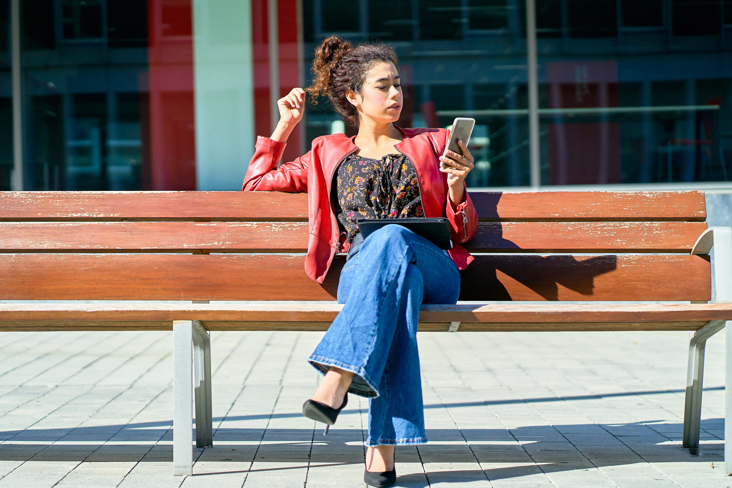 woman sitting on a bench using her phone