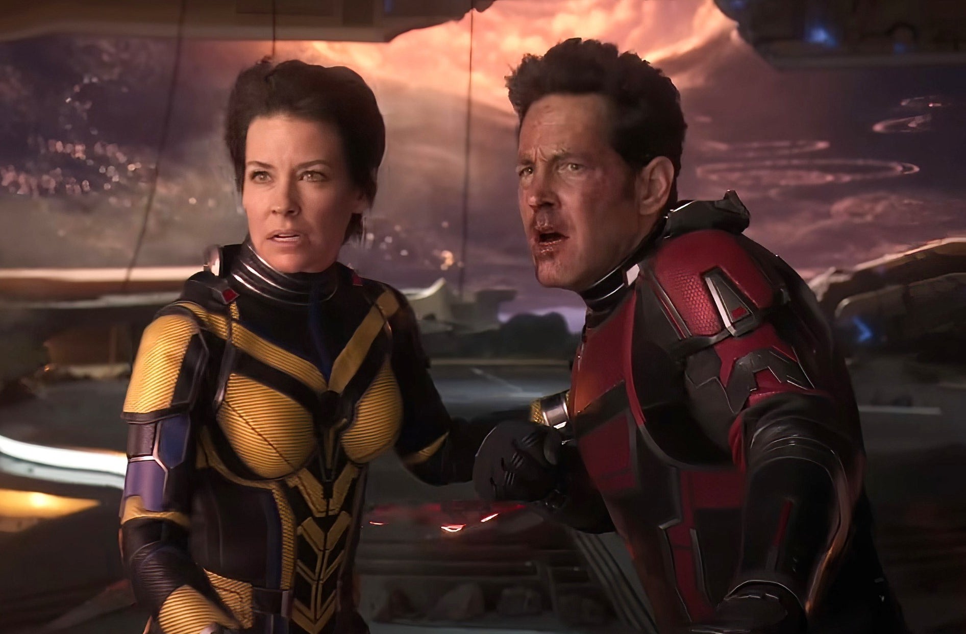 Ant-Man and the wasp look surprised while standing front of a futuristic background
