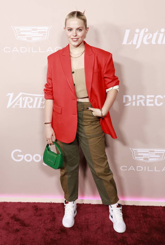 Reneé poses at a red carpet event wearing ankle-length pants, a crop top, a blazer, and Nike&#x27;s