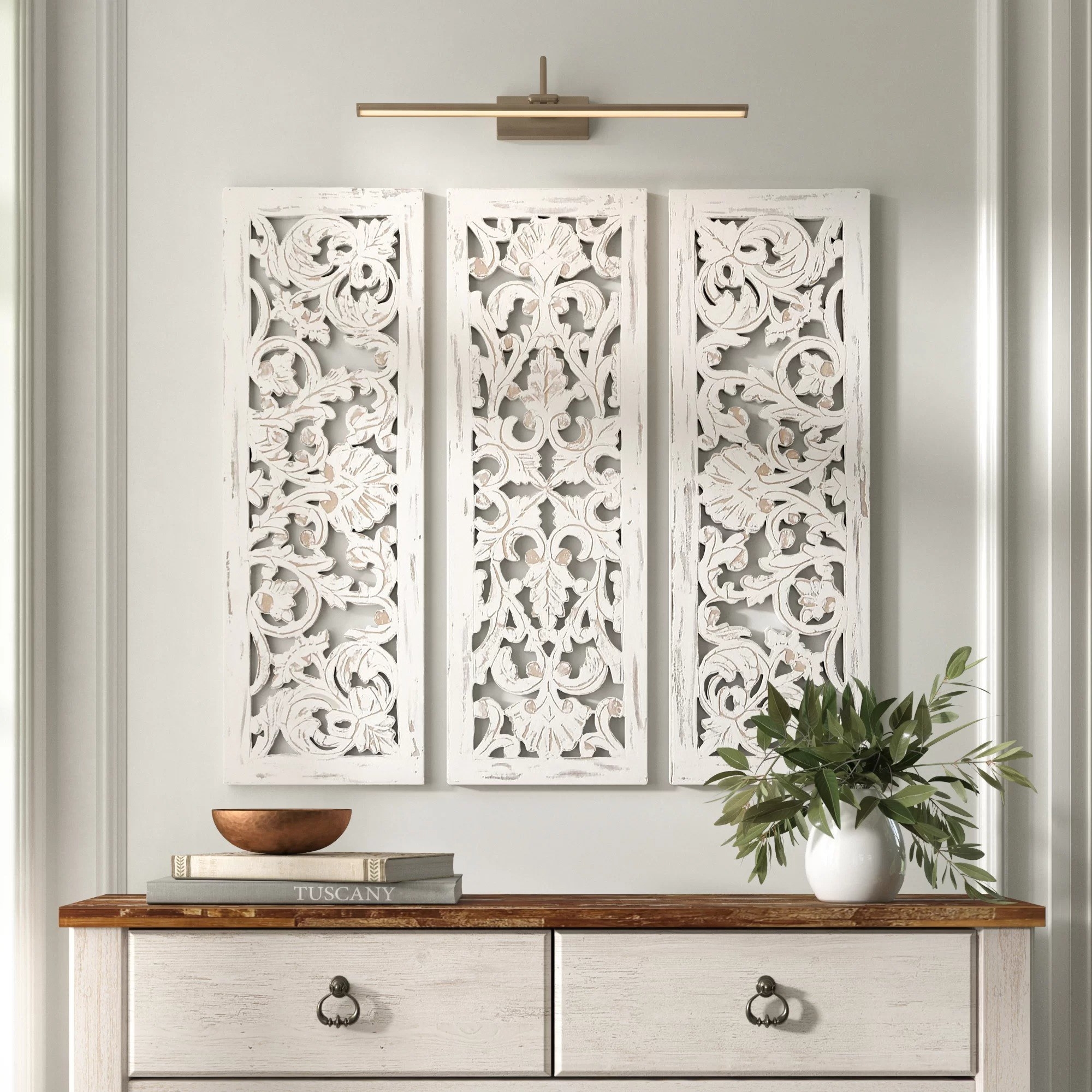 The three-piece wall decor set with an intricate floral pattern hanging on a wall