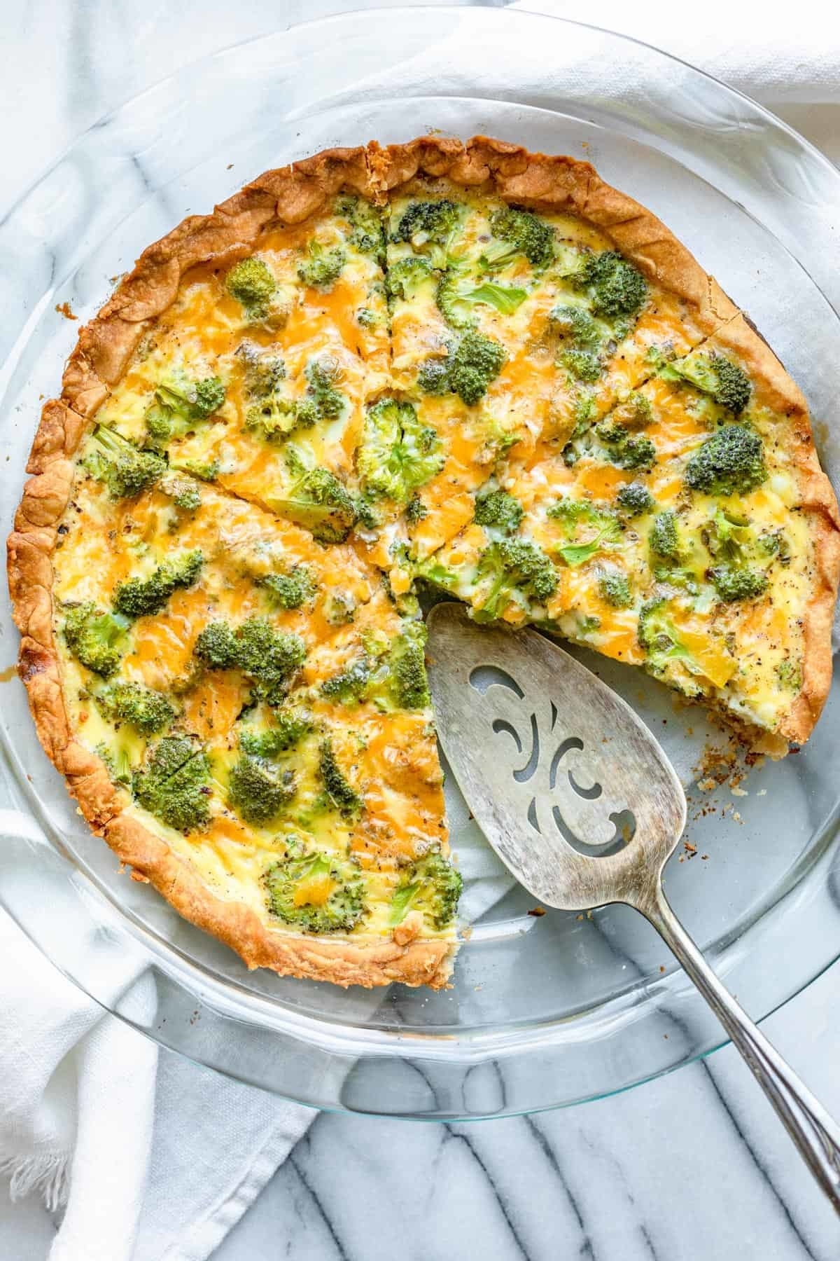 A broccoli and cheese quiche cut in slices.