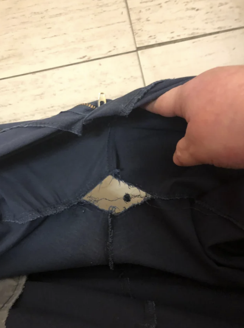 A large split in a person&#x27;s pants below the crotch area