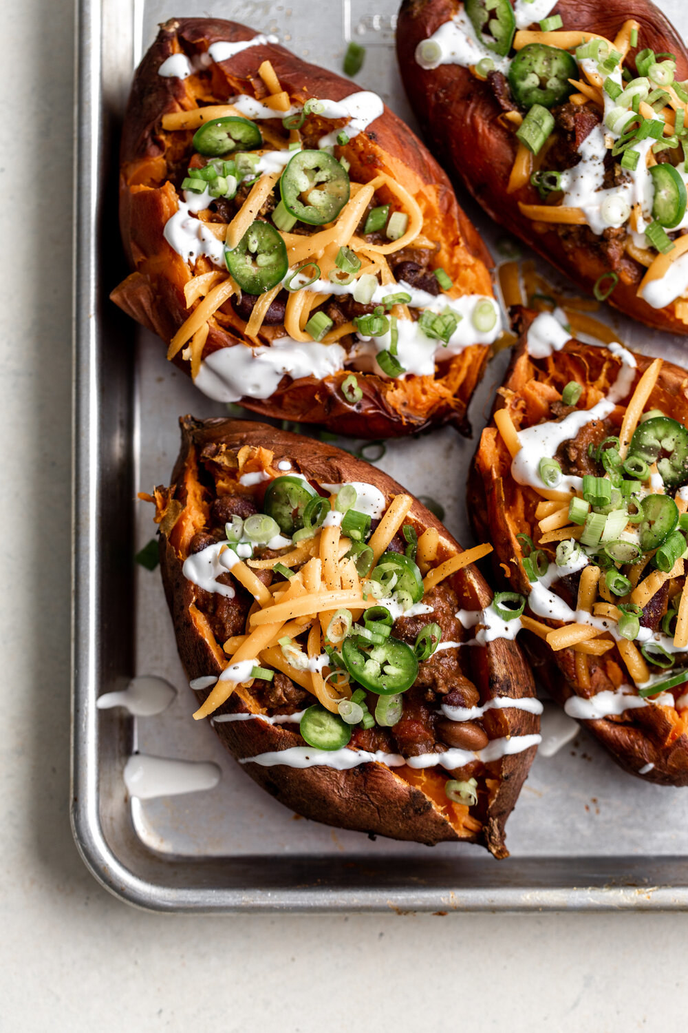 Baked potatoes topped with chili, jalapeño, and cheese.