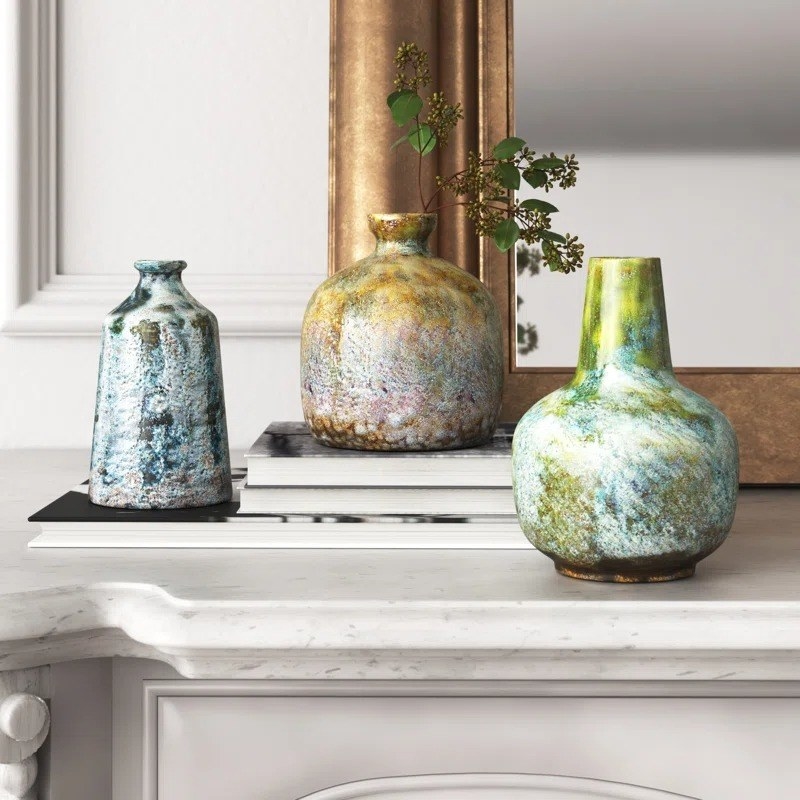 The earth-toned vases on a mantle