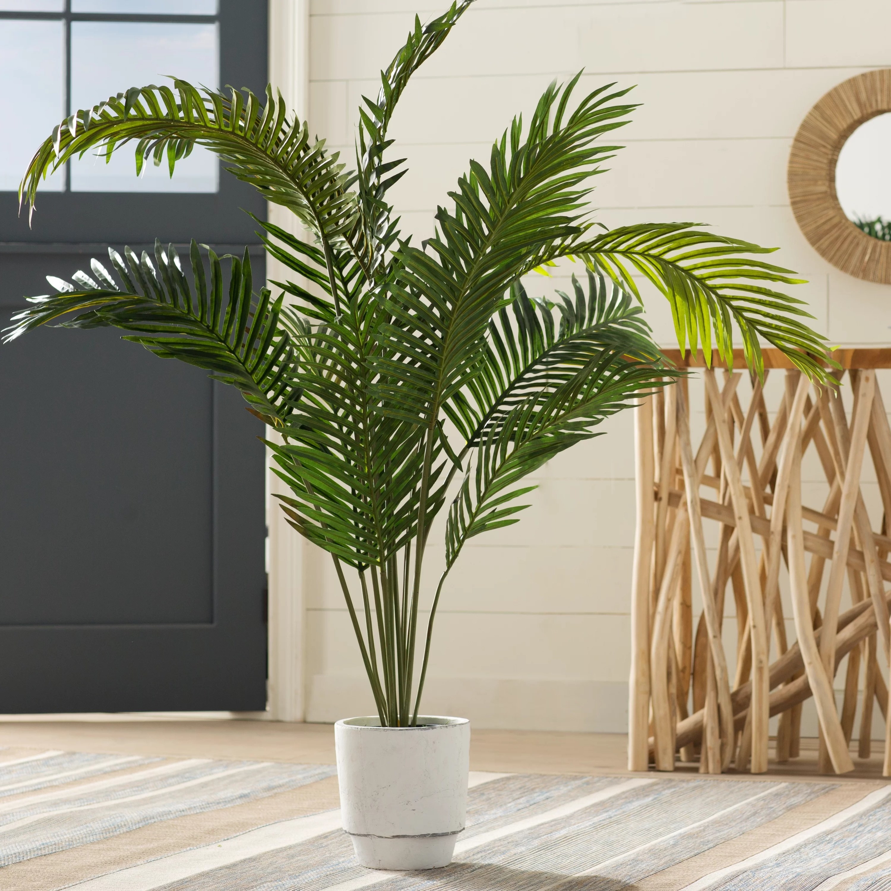 The faux palm plant in a planter, in a living room