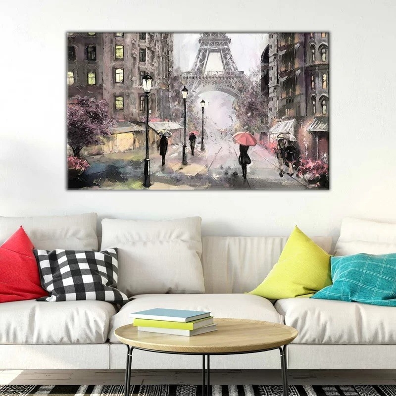 The canvas print of a Paris street hanging above a couch