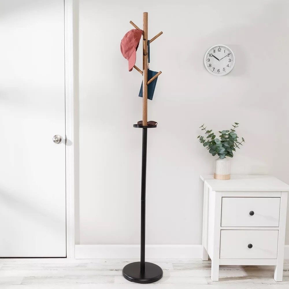 the coat rack with a hat and purse hanging on it