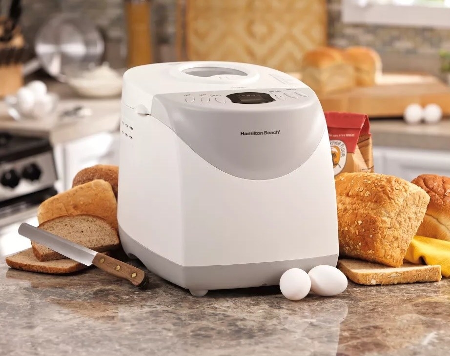 The breadmaker next to loaves of bread