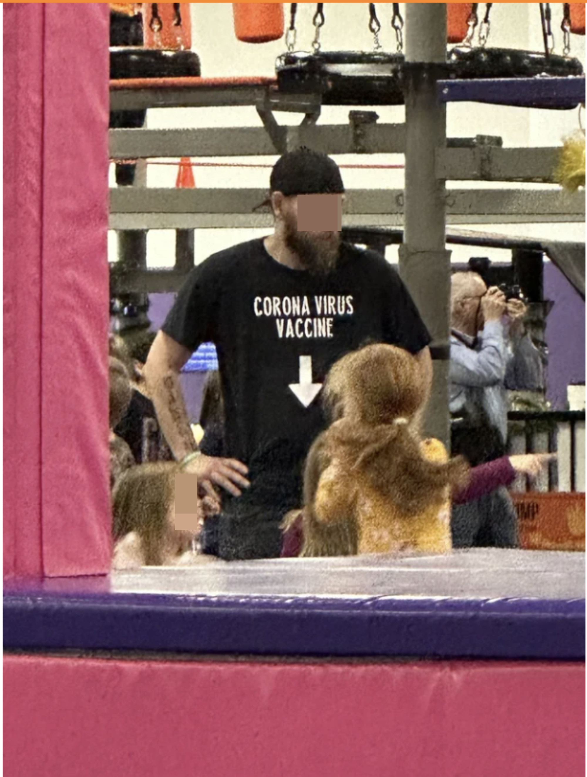 A man wearing a shirt that says &quot;Coronavirus Vaccine&quot; with an arrow pointing downward