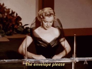 Marilyn Monroe opening an envelope at the Oscars