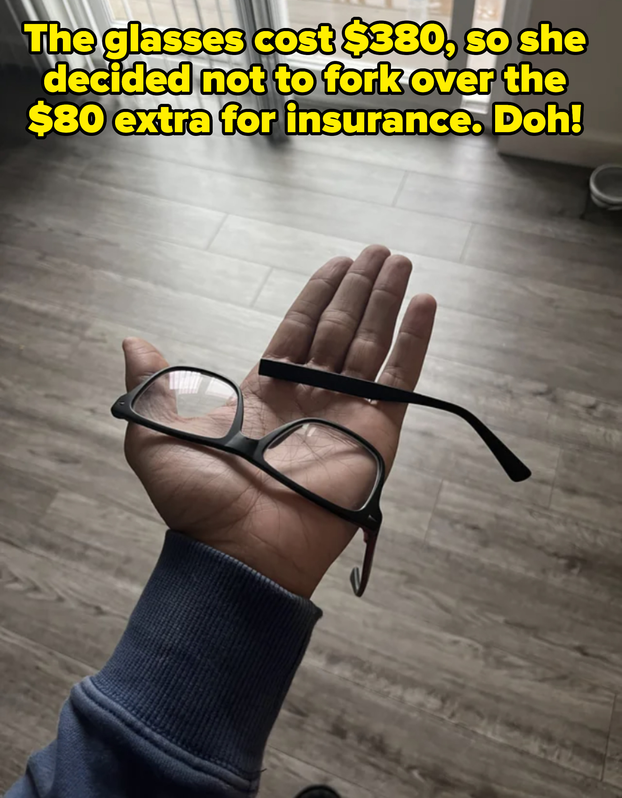 A hand holding broken glasses