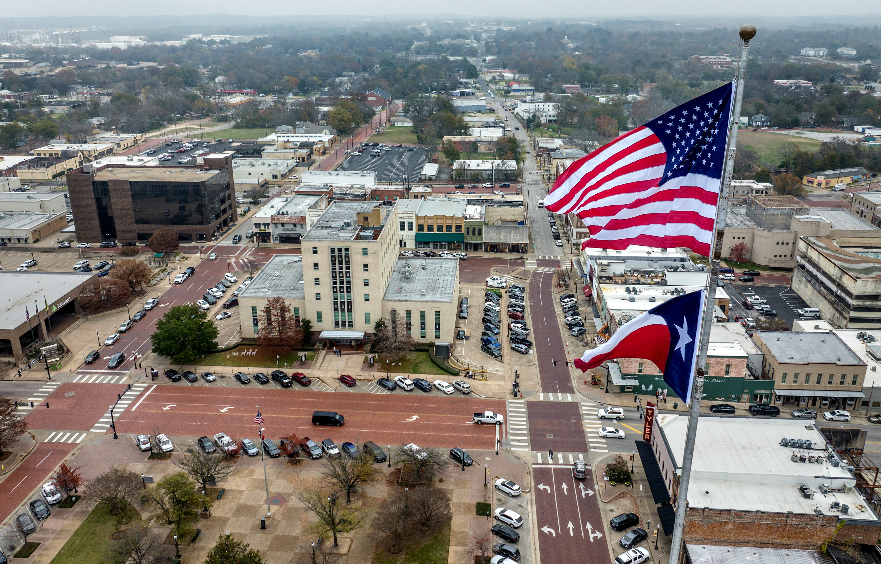 The United States and Texas flags fly in front of the Smith County courthouse in Tyler, Texas on December 9, 2022.