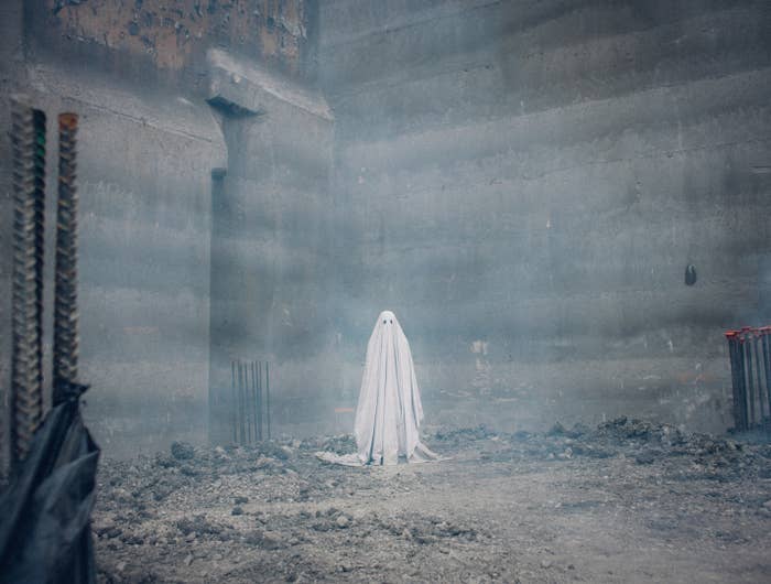 a ghost under a white sheet blanket standing in a construction site