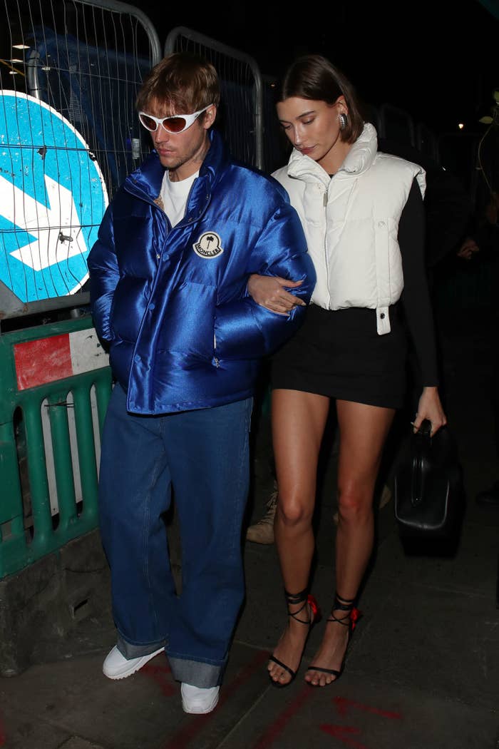 Justin and Hailey Bieber walking outside arm-in-arm. It&#x27;s nighttime as they walk down the street