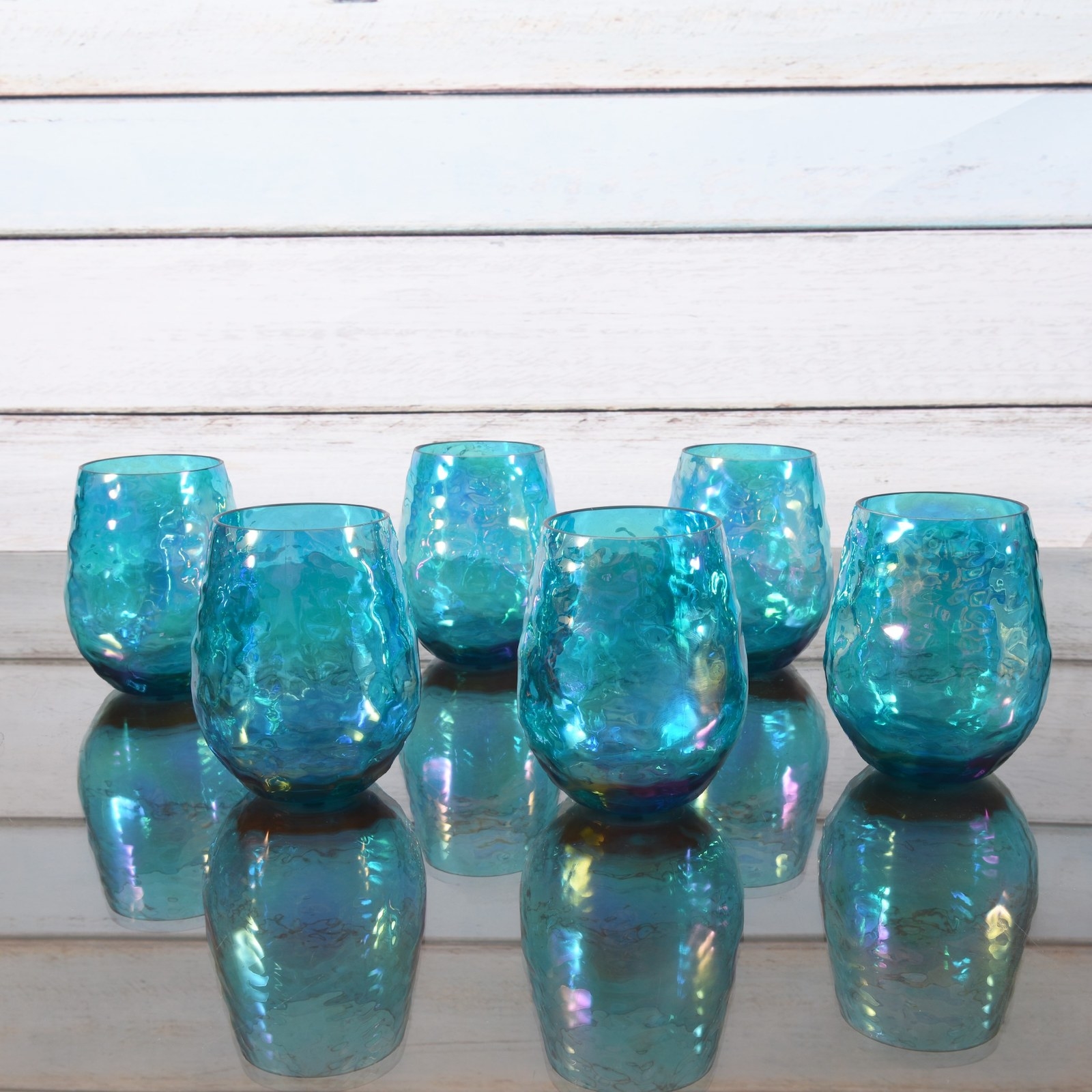 The set of six stemless blue glasses on a table
