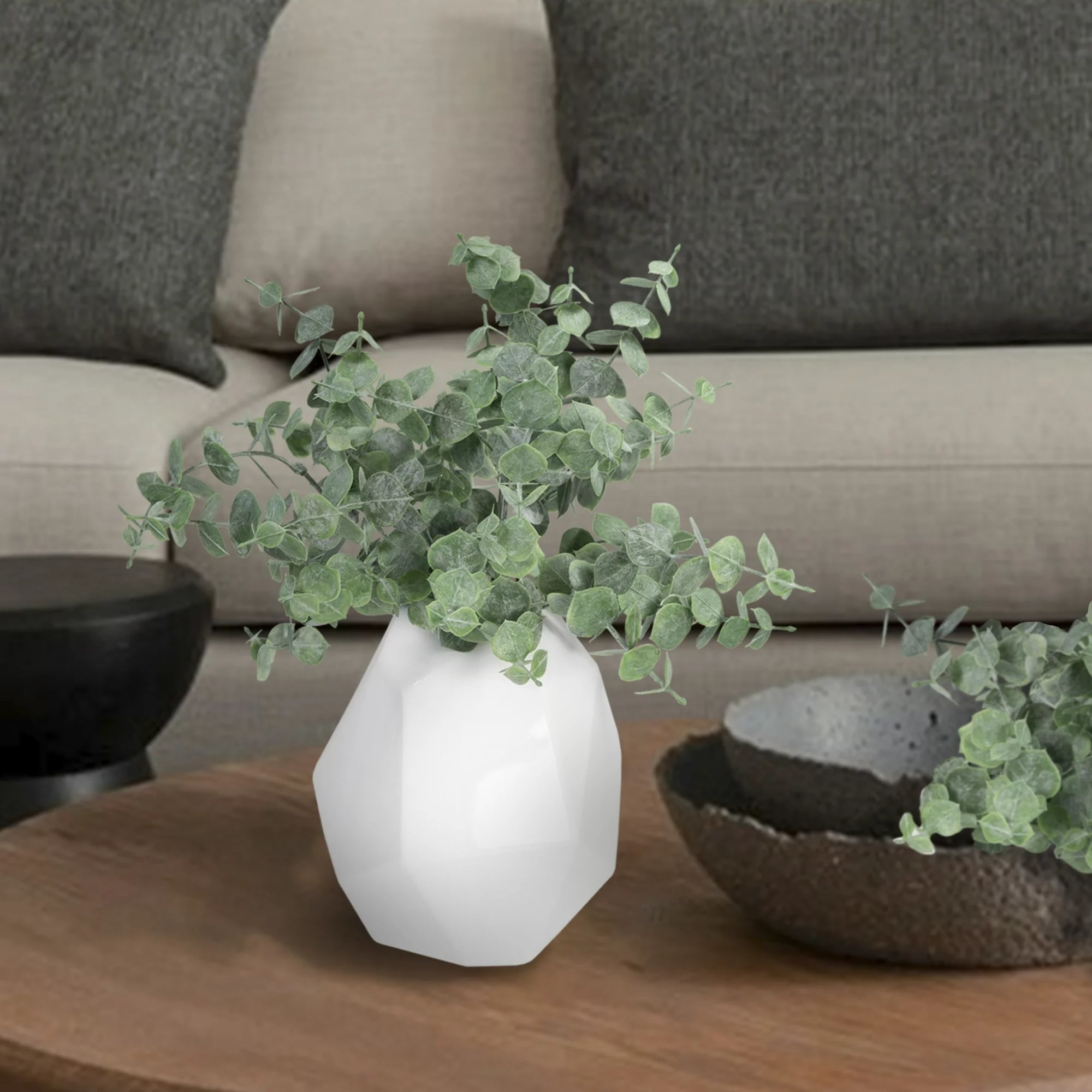 The faux eucalyptus plant in a white vase