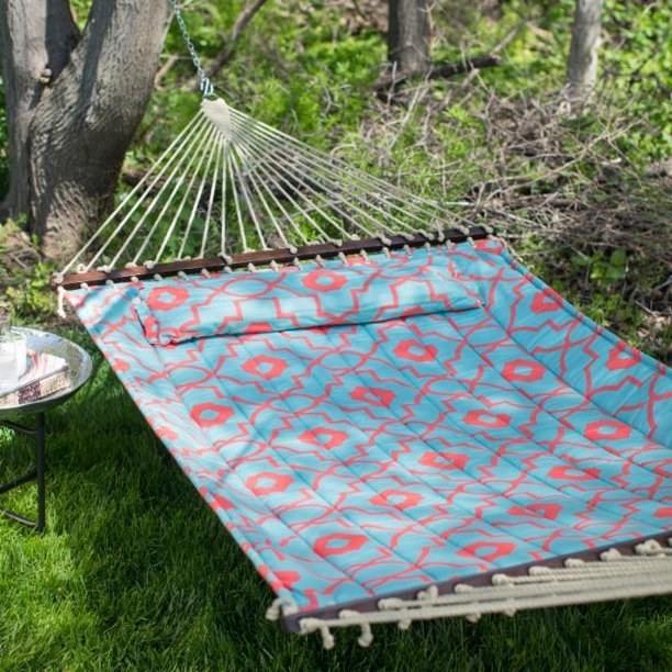 The large hammock with a matching pillow in a backyard