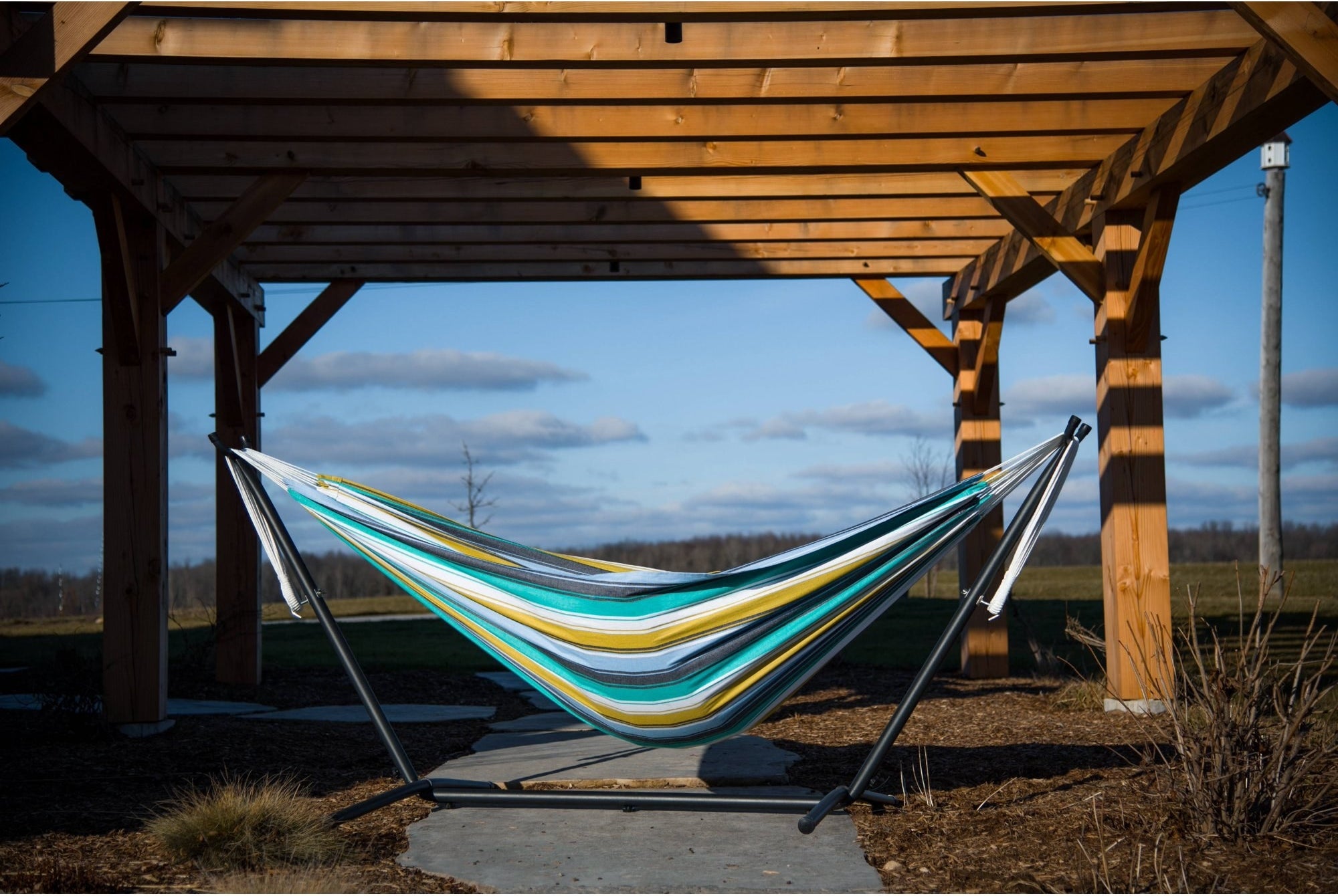 striped yellow and blue double hammock outside