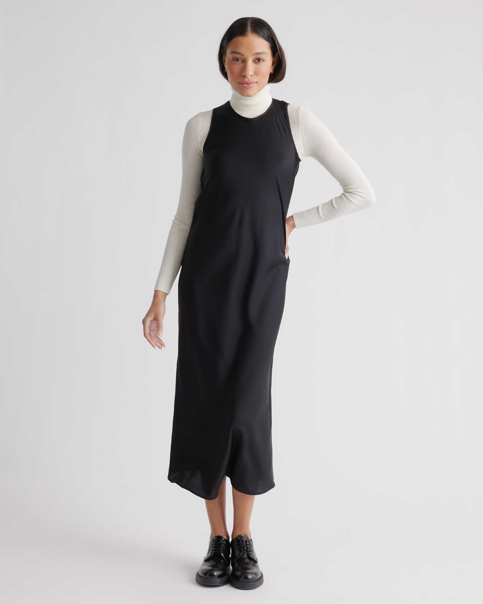 model in blank silk midi dress with high round neck and wide tank sleeves