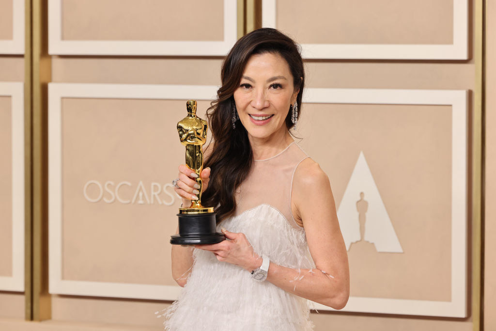 Michelle Yeoh holding up her Oscar backstage