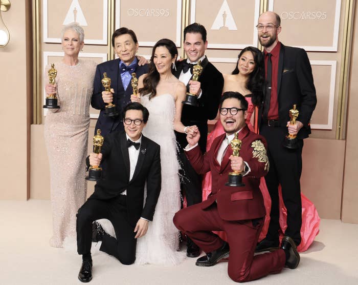 The cast and directors of Everything Everywhere All at Once poses on the champagne carpet with their Oscar awards