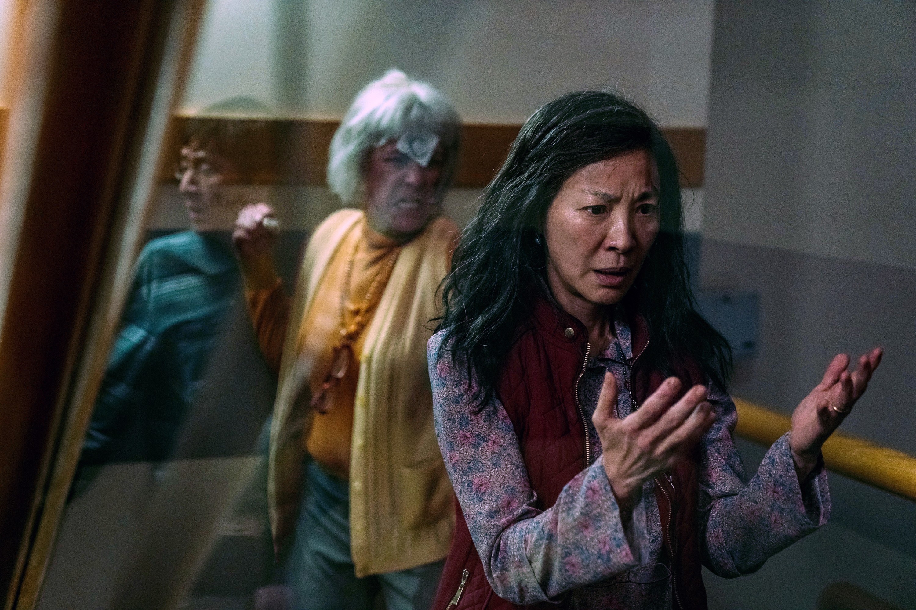Michelle Yeoh looking at her hands in concern in a scene from Everything Everywhere All at Once