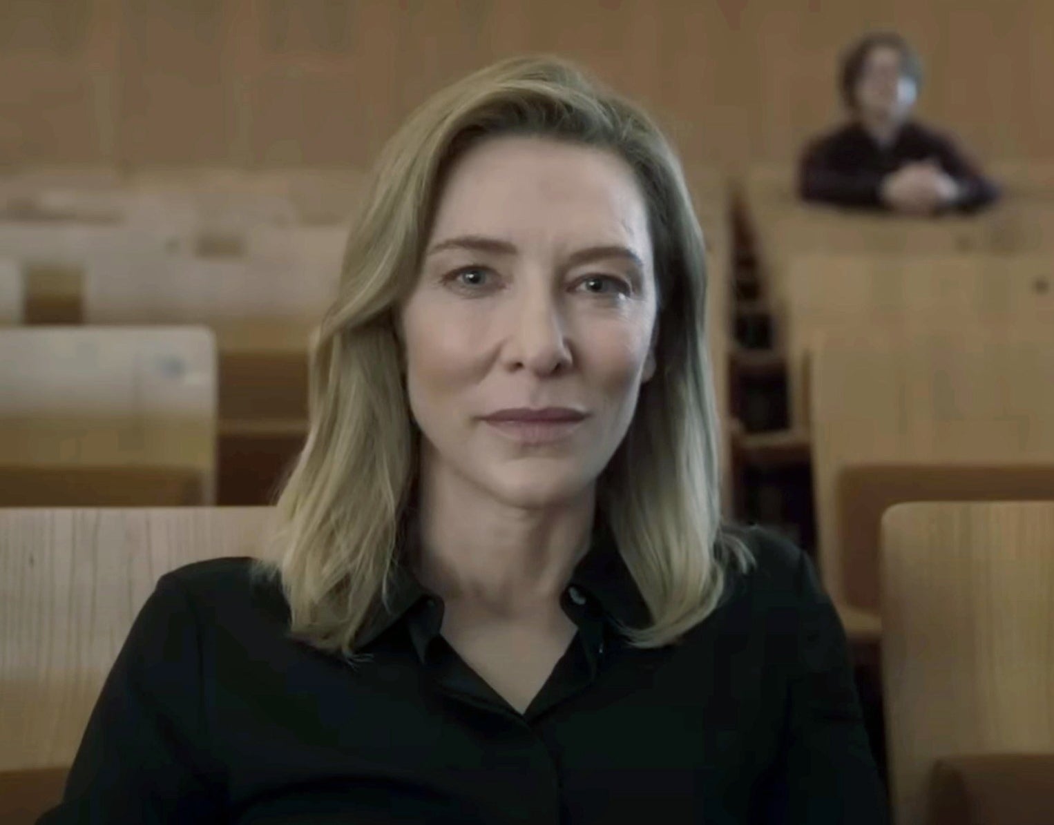 A closeup of Cate as Lydia Tàr sitting in an auditorium in the film Tàr