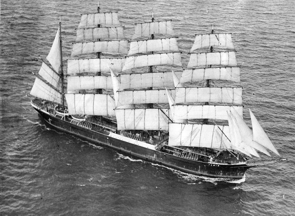 A large ship with masts in the water