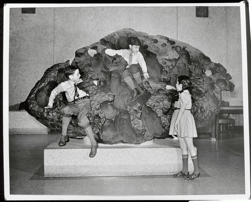 Children climbing on a meteor on display