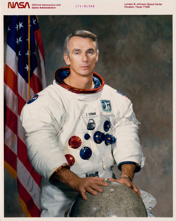 Man in a spacesuit with a globe in front of him