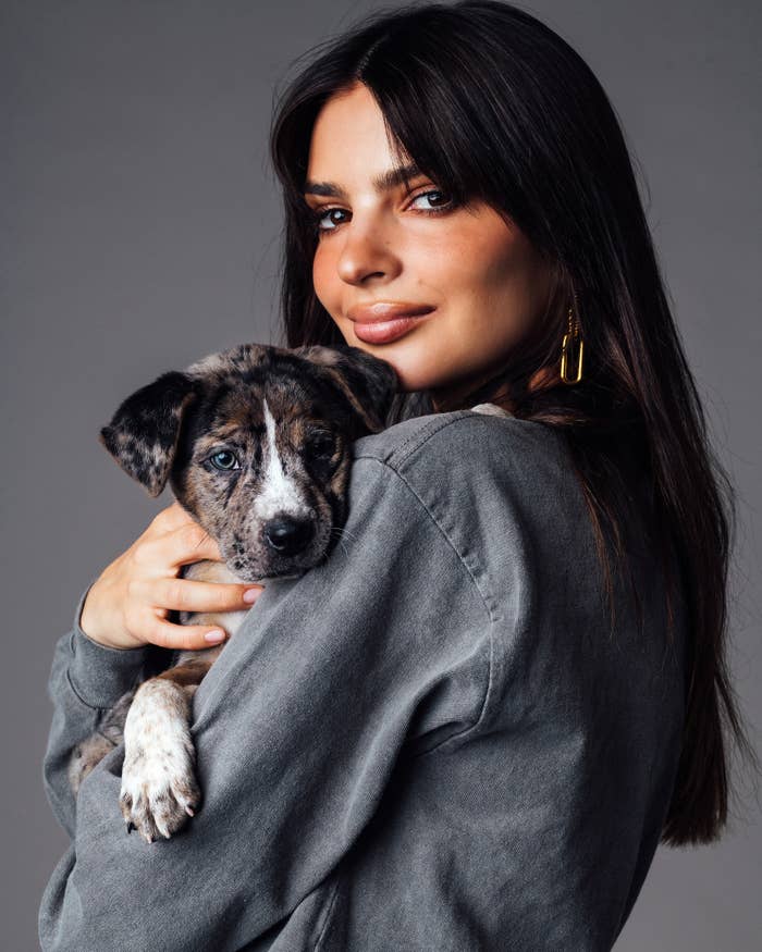 Emily looks at the camera as she holds a puppy close in her arms