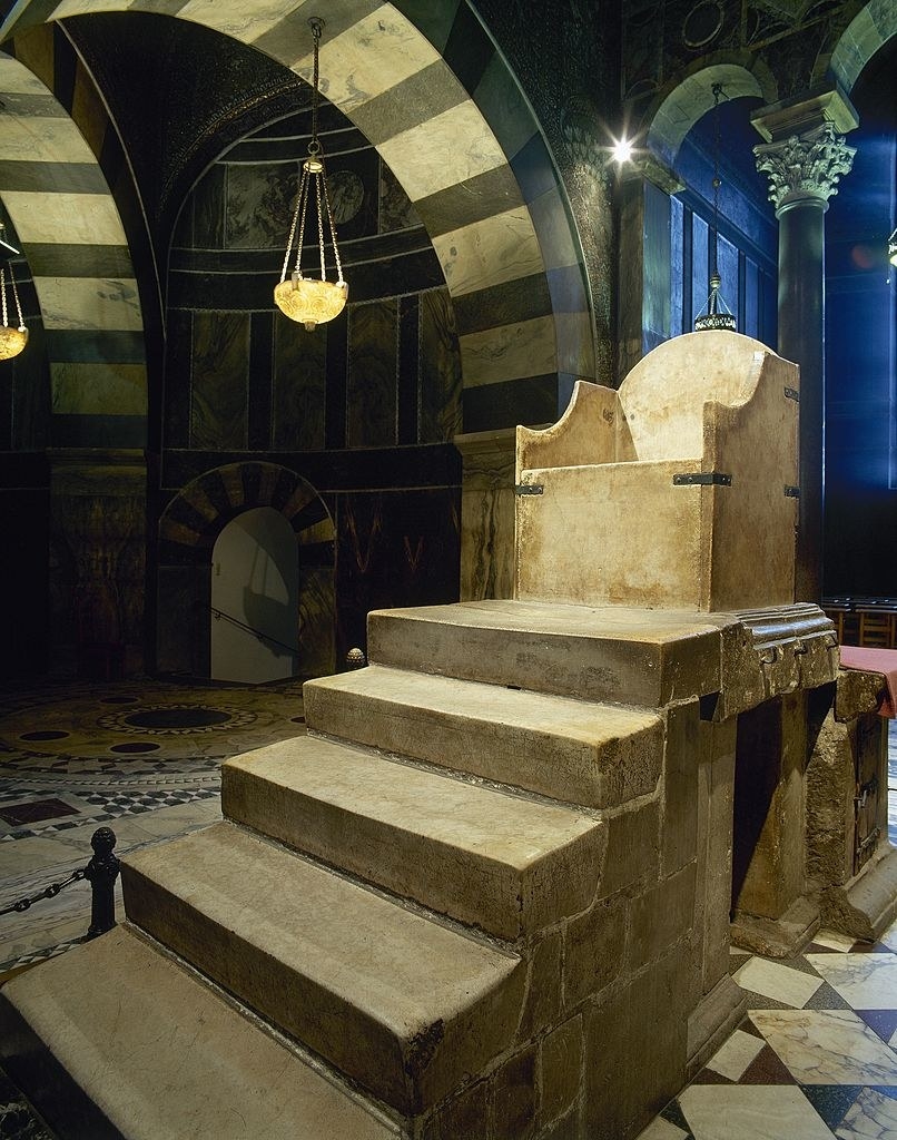 Five stone steps leading up to a small chair/throne