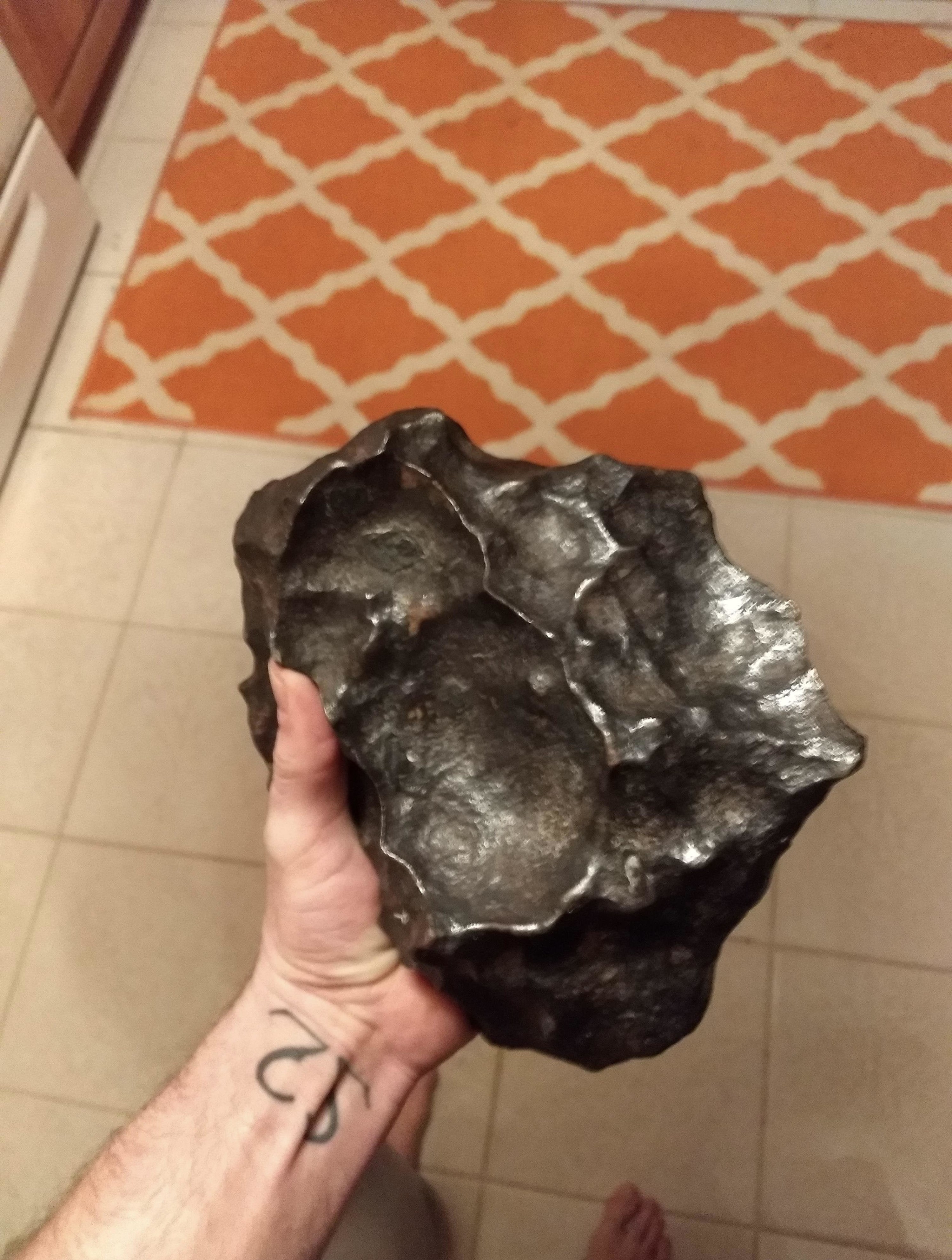 A person holding a chunk of rock/metal