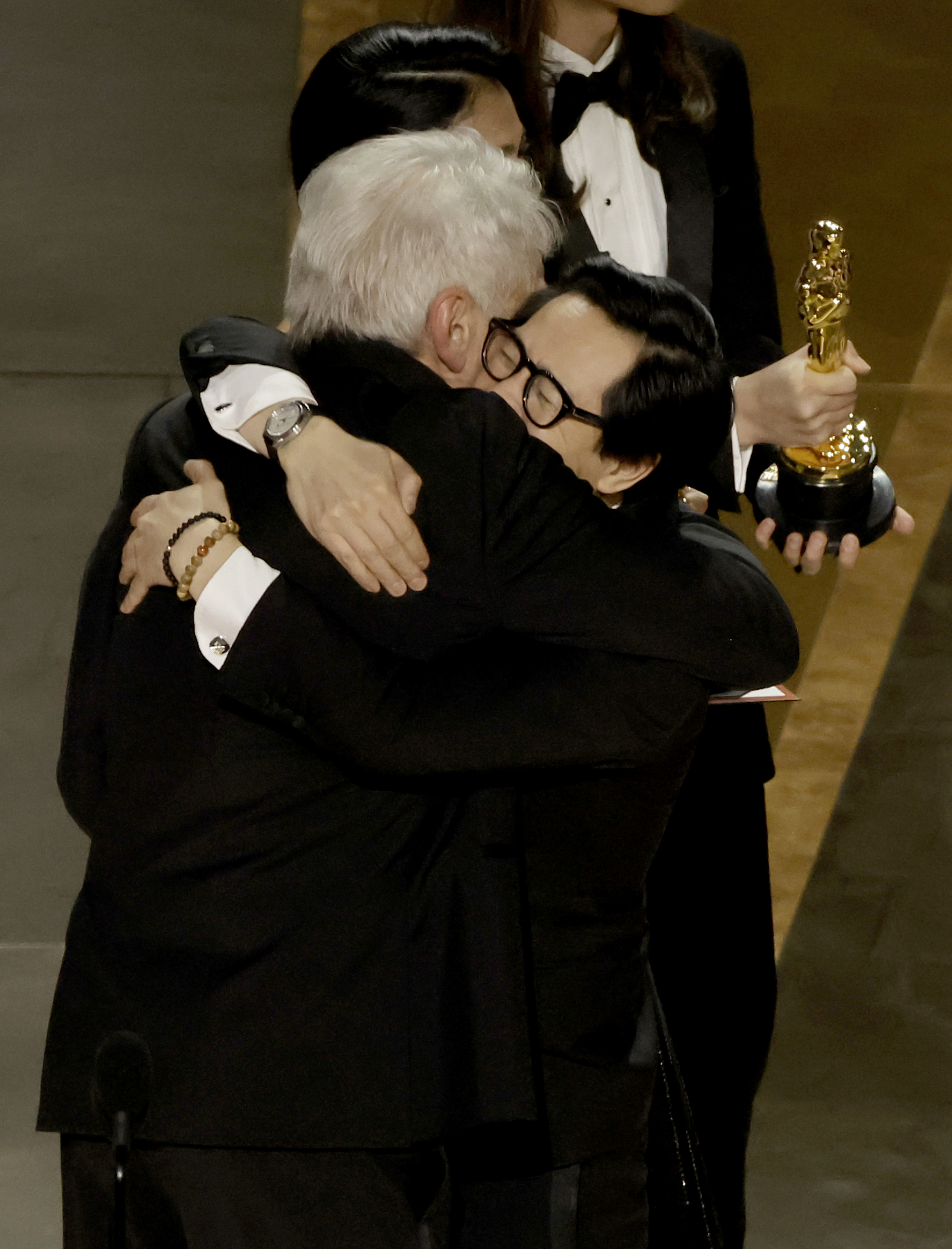 Ke Huy Quan and Harrison Ford hug on stage