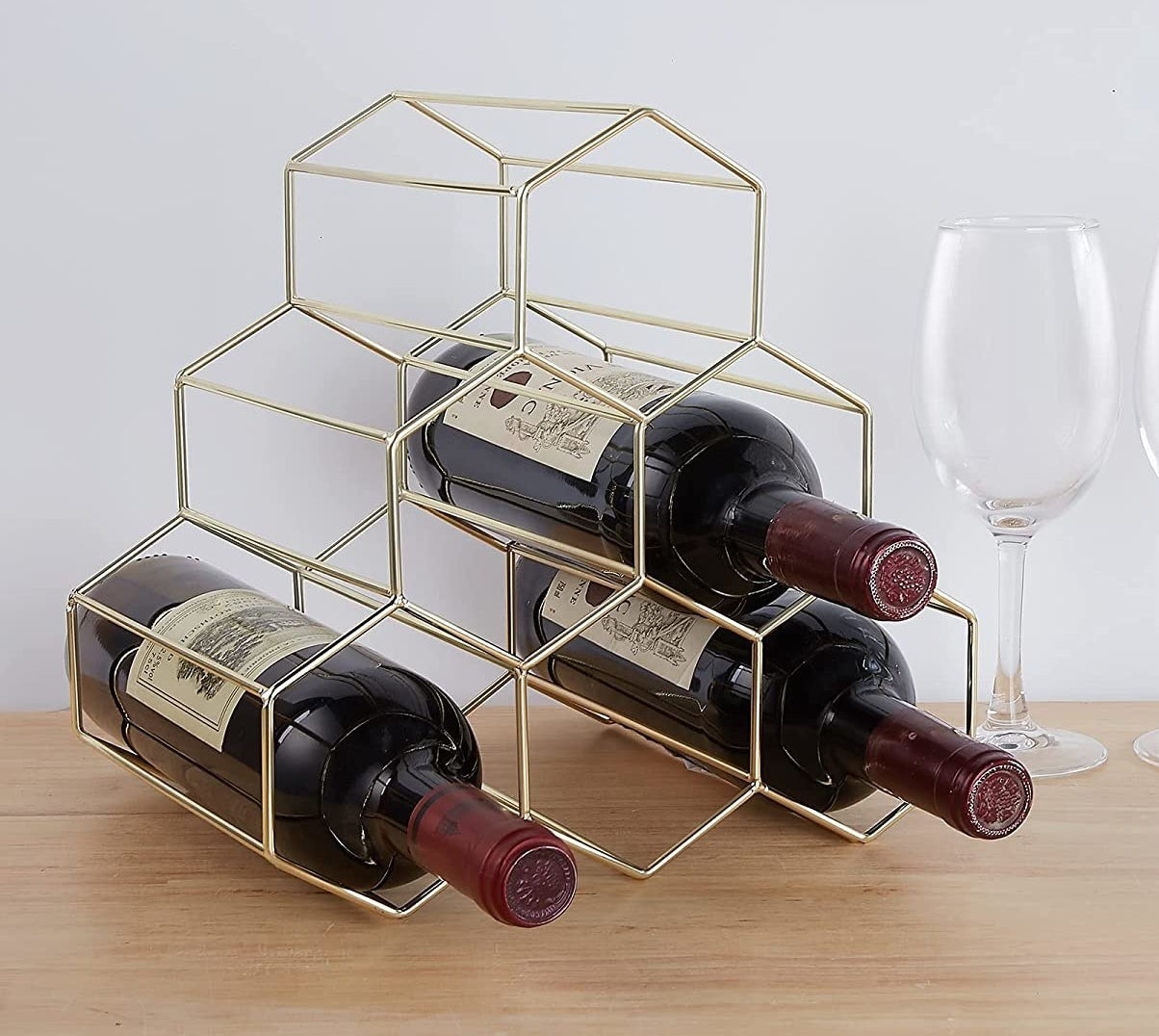 three bottles of wine on the wine rack on a wooden table