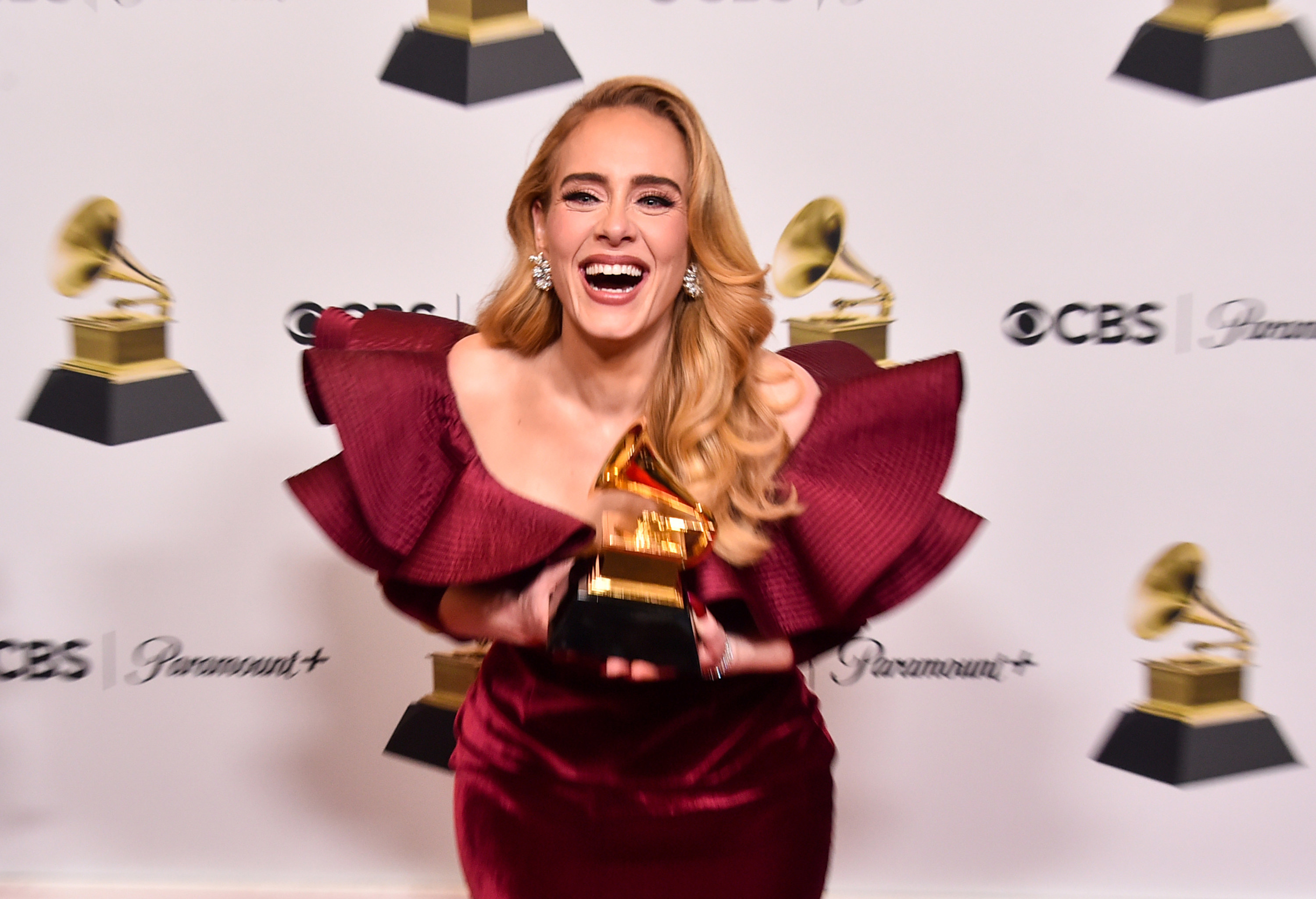 Adele laughing as she shows off her Grammy backstage