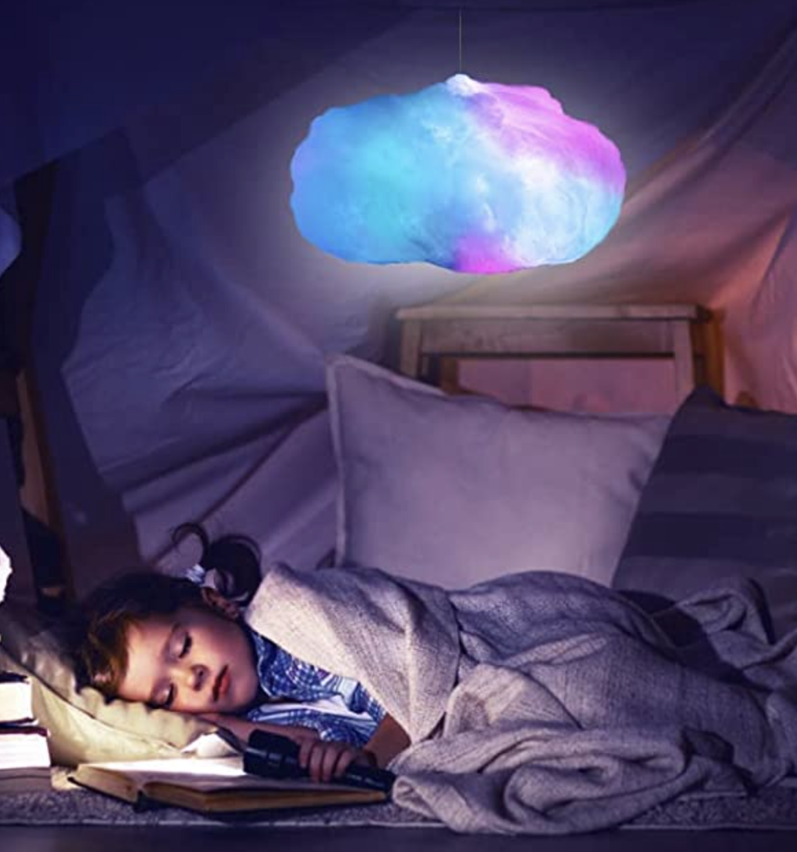 a kid sleeping in a blanket fort under a cloud lamp