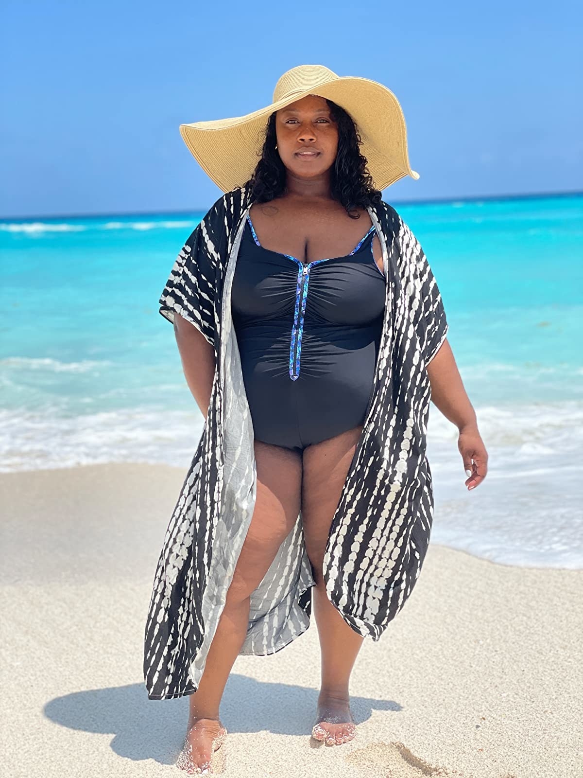 Reviewer wearing black and white patterned coverup with a one-piece swimsuit