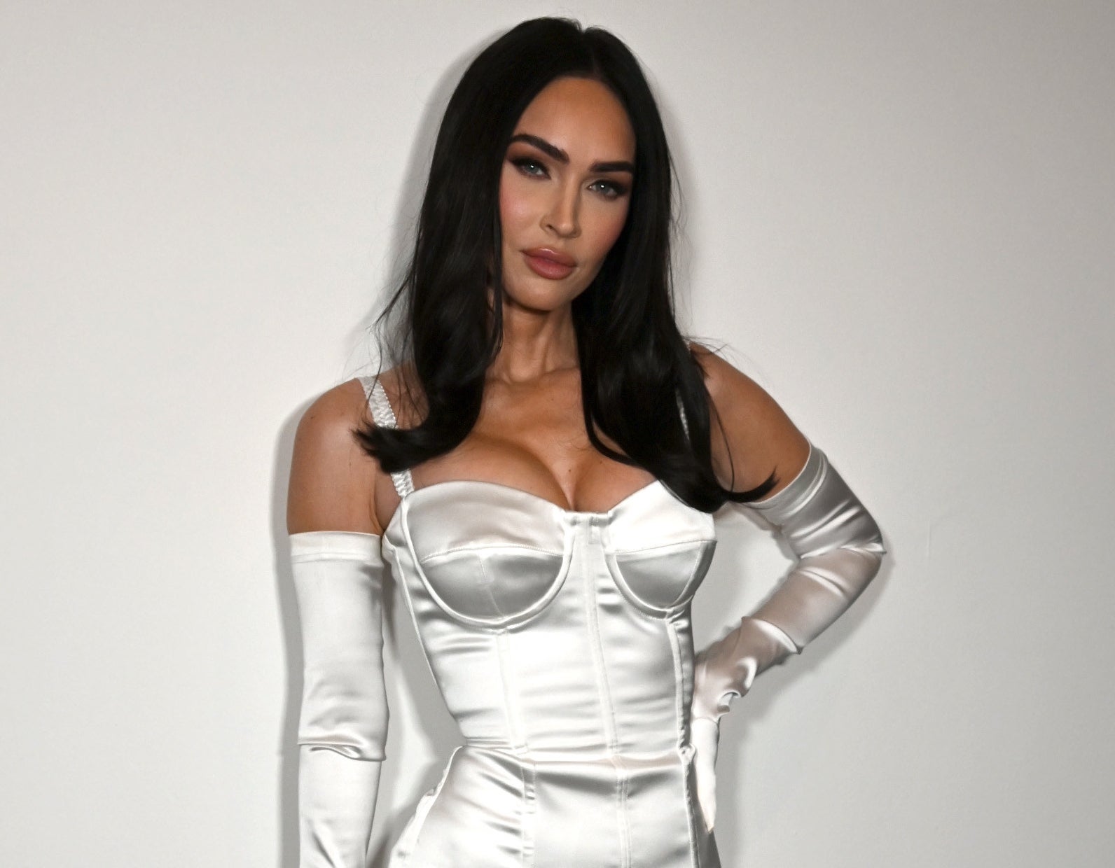 A close-up of Megan in a satiny corset-type outfit and opera gloves