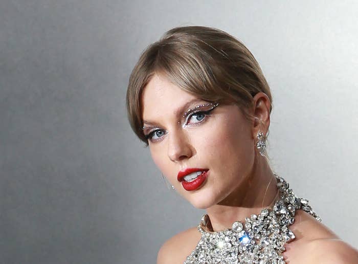 A closeup of Taylor wearing a bejeweled halter neck outfit. Her hair is swept into a bun