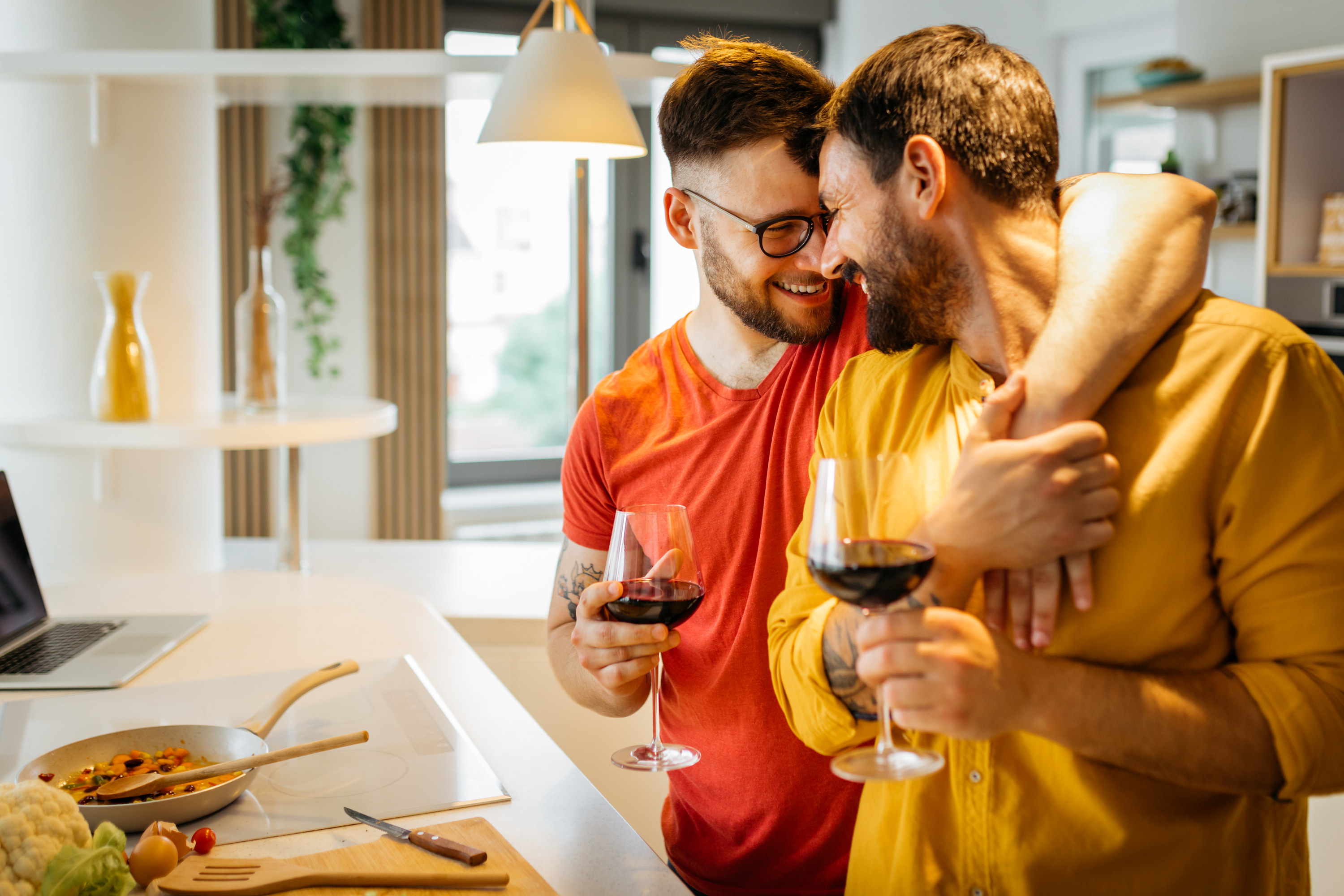 two men drinking wine and hugging