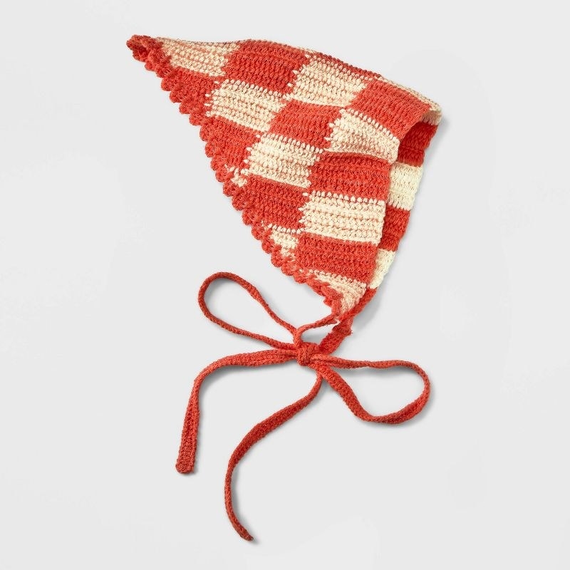 The crochet headscarf in an ivory and orange checkered pattern