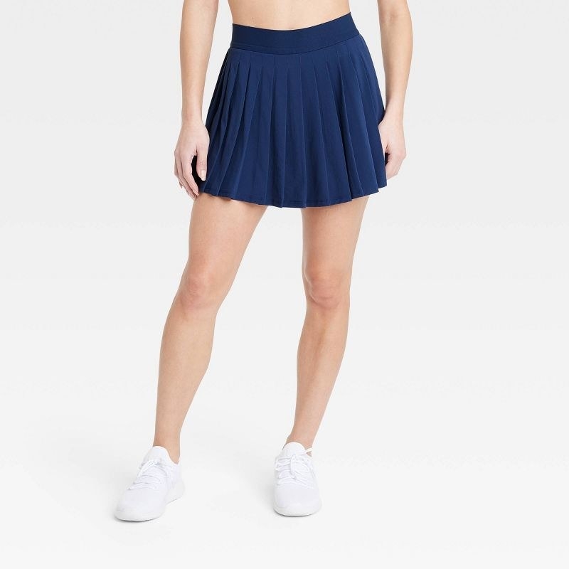 A model in the navy mini skirt, which falls mid tigh