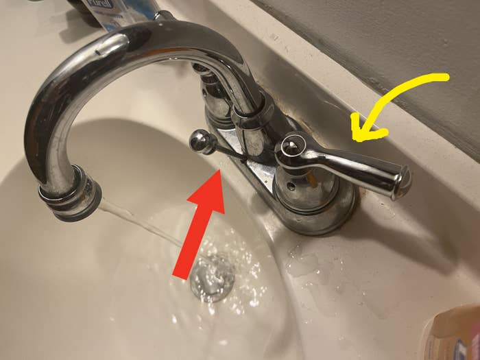 A faucet has the handles and drain tab on the wrong side
