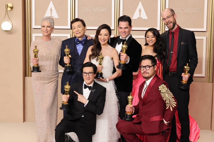 The cast and directors of Everything Everywhere All At Once pose for a group photo while holding their Oscars